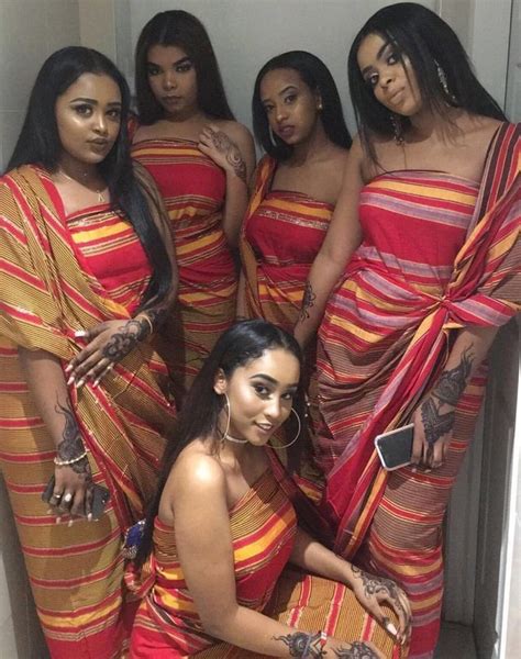 A Group Of Women Standing Next To Each Other Wearing Matching Sari And