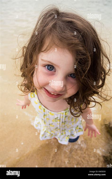 Portrait Of A Young Girl Standing In The Water At The Beach While On
