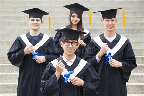 Students In Graduation Gowns On University Campus Stock Photo Image