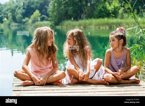 Portrait Of Young Female Threesome Having Conversation On River Jetty