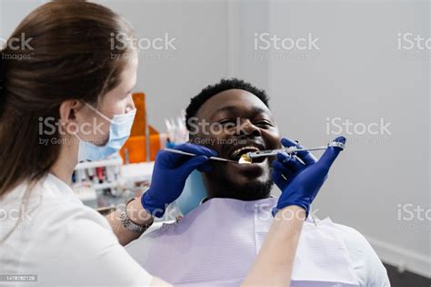 El Dentista Inyecta Una Jeringa Con Anestesia En La Boca Del Hombre