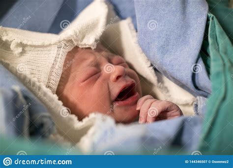 Newborn Eyes Closed Crying Baby In Green Blanket In
