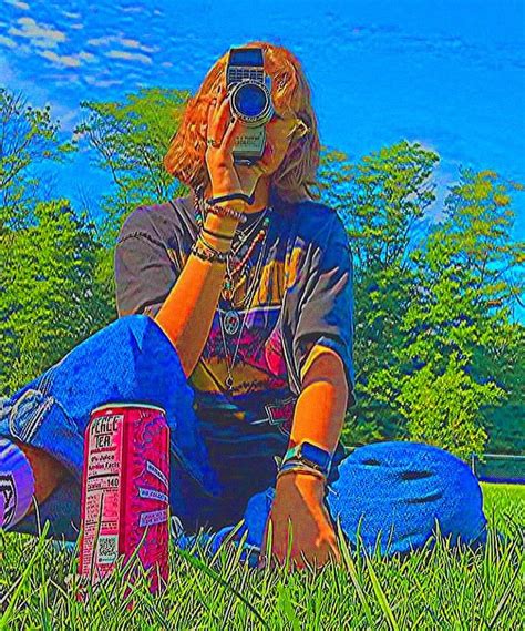 A Person Sitting In The Grass With A Camera On Their Head And Some Cans