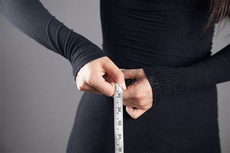 Young Woman Measuring Abdominal Circumference With Measuring Tape Stock