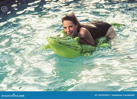 Beautiful Woman In Water With Green Inflatable Crocodile Stock Photo