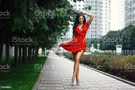 Nice Tanned Stylish Brunette Girl In Red Short Dress With Flowers Is