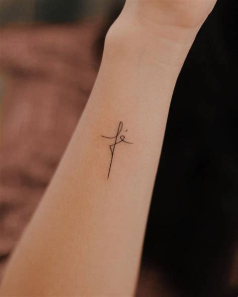 Tattoo Of The Word Fé Shapped As A Cross Located On