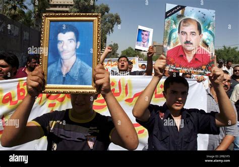 Men Hold Photos Of Their Dead Relatives As Nearly 300 Shiite Residents