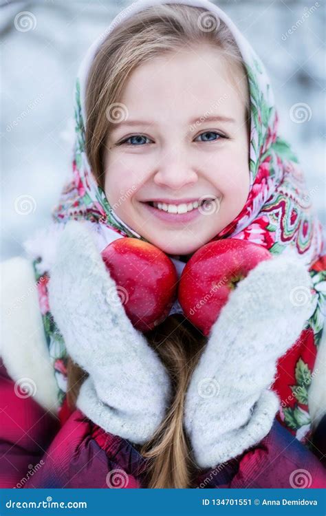 beautiful teen girl in russian national clothes with red apples in winter hands stock image