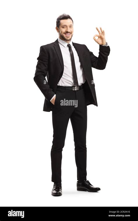 Full Length Portrait Of A Young Man Wearing Black Suit And Gesturing Ok