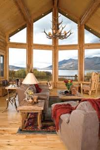 Luxurious open floor rustic cabin interior dinning room design with roaring stone fireplace and winter scenic background. Rustic cabin interior design ideas