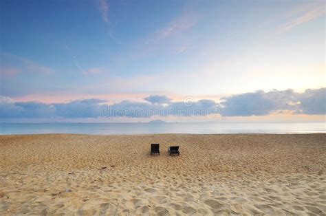 The Beach Chairs On Sand Beach During Sunrise Or Sunset Stock Photo
