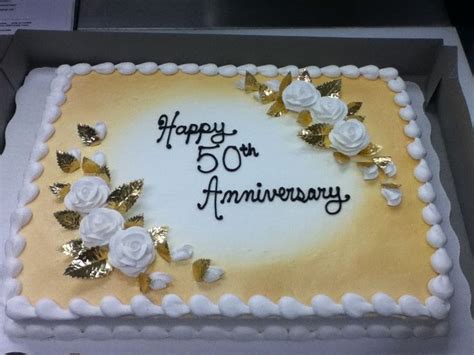 A 50th Anniversary Cake With White Roses And Gold Leaves