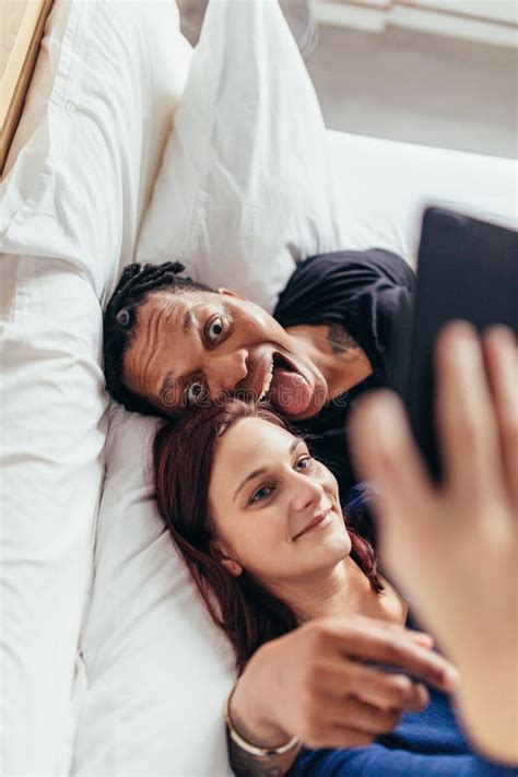 Couples Multiraciaux Prenant Le Selfie Dans Le Lit Image Stock Image Du Téléphone Masculin