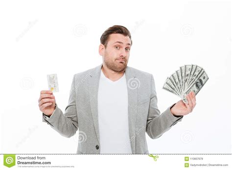 Confused Young Businessman Holding Credit Card And Money Stock Image