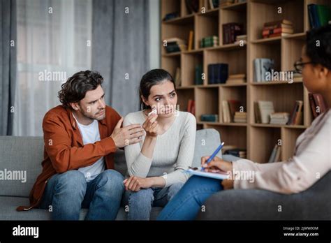 Unhappy Sad Millennial Caucasian Man Calms Crying Woman At Meeting With