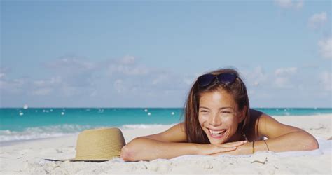 Beach Woman Wearing Sunglasses And Sun Hat Relaxing On Beach Towel Sunbathing Skincare Solar Uv