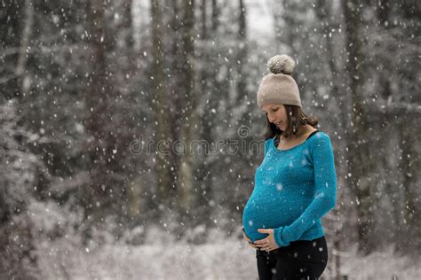 pregnant woman holding her belly standing outside during snowfal stock image image of blue