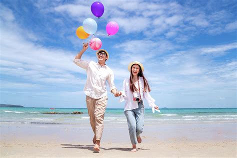 Asian Couple Run And Happy On Pattaya Beach With Balloon On Hand
