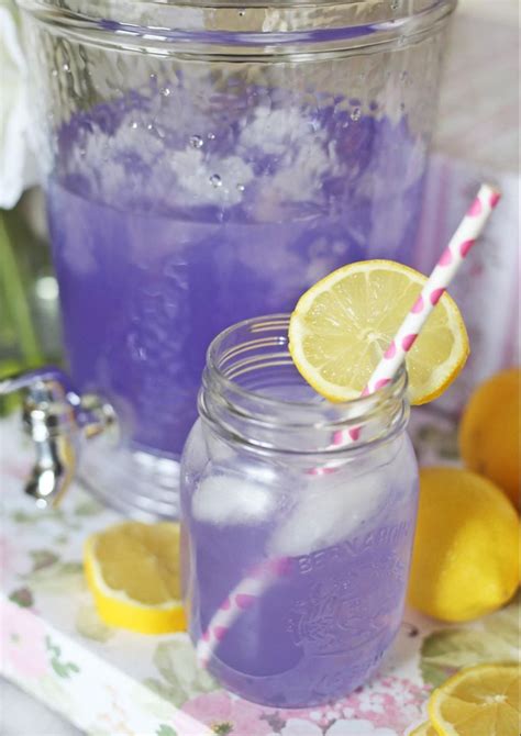 Two Mason Jars Filled With Purple Liquid And Lemons On A Table Next To
