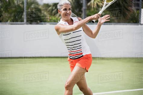Mature Woman Playing Tennis At Court Stock Photo Dissolve