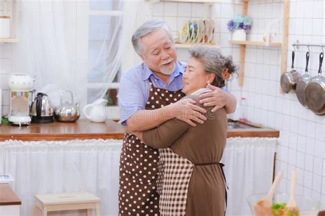 Asian Happy Retired Senior Smiling Cute Elder Couple Hugging Stock