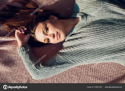 Beautiful Sexy Tan Brunette Woman Posing In Bedroom Wearing Cozy Grey
