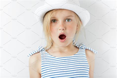 Close Up Portrait Of Amazed Adorable Little Girl In White Hat And