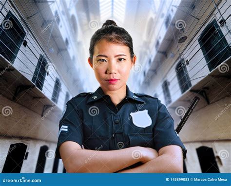 Young Serious And Attractive Asian Chinese Guard Woman Standing At State Penitentiary Prison