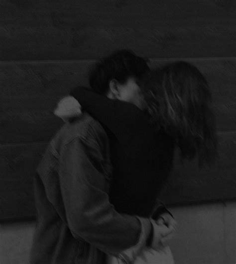 Black And White Photograph Of Two People Kissing On The Street With One
