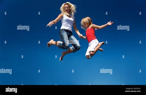 una madre y su hija saltando alto teniendo porciones de diversión fotografía de stock alamy
