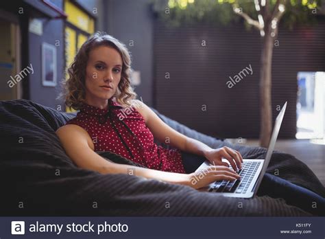 Portrait Of Confident Young Woman Sitting With Laptop On Bean Bag