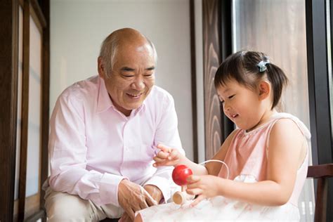 Grandfather Watching Granddaughter Play With Traditional Japanese Toy 照片檔及更多 孫輩 照片 Istock
