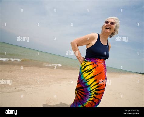 Happy On The Beach An Older Woman Dressed In A Bathing Suit Top And A