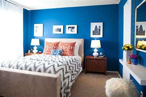 A luxurious primary bedroom with dark blue accent wall and platform bed. Moody Interior: Breathtaking Bedrooms in Shades of Blue