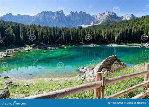 Turquoise Mountain Lake With A Railing In The Middle Of The Forest And