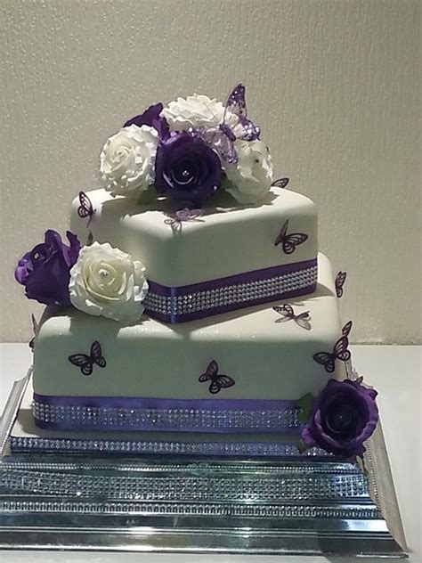 A 2 Tier Square Wedding Cake In Ivory Finished With Purple And Ivory