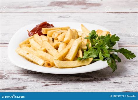 White French Fries Plate With Ketchup And Parsley On White Table Stock