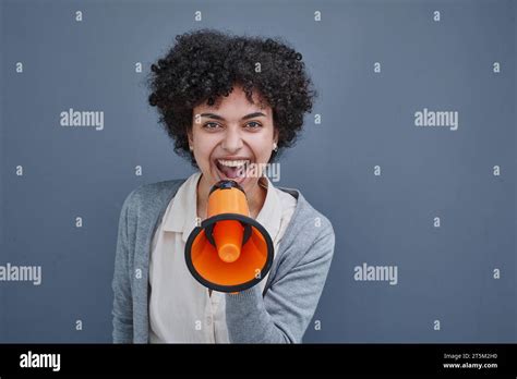 A Girl On A Gray Background Holds A Loudspeaker In Her Hand Screams