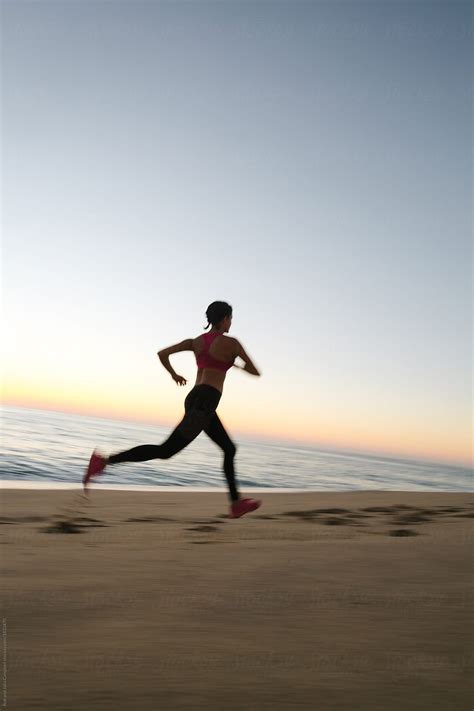 Fit Woman Running And Working Out On The Beach At Sunset By Stocksy Contributor Rob And Julia