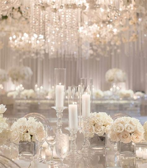 The Table Is Set With White Flowers And Candles For An Elegant Wedding