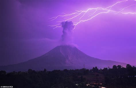 Lightning Bolt Strikes Above Erupting Volcano Turning Sky Purple