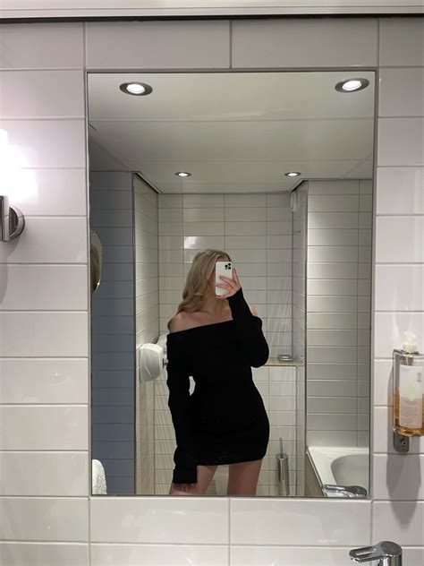 A Woman Taking A Selfie In Front Of A Bathroom Mirror With The