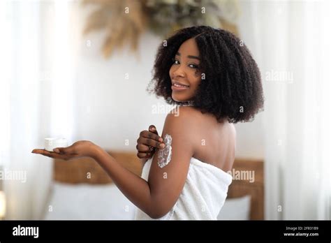 Happy Black Woman Applying Cream Onto Her Body After Shower Indoors Stock Photo Alamy