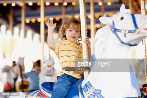 Usa California Los Angeles Boy Sitting On Carousels Horse And Waving