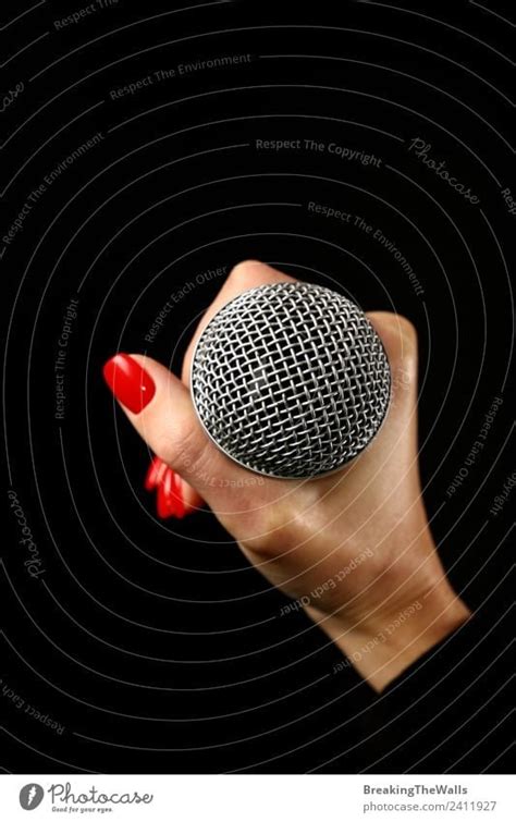 Woman Hand Holding Microphone On Black Background A Royalty Free