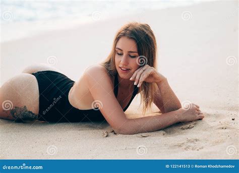 närbilden av en flicka som solbadar på stranden lögner på hennes mage visar hennes härliga röv