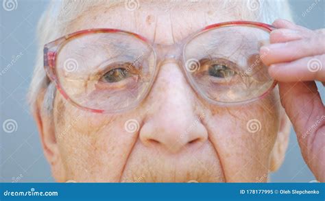 detail portrait of granny in eyeglasses with pensive sight close up wrinkled face of female