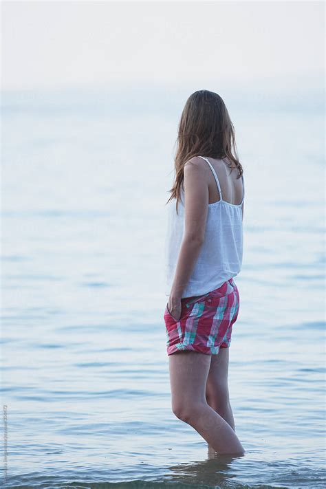 Woman Stands Casually In The Shallow Water Of The Sea Del