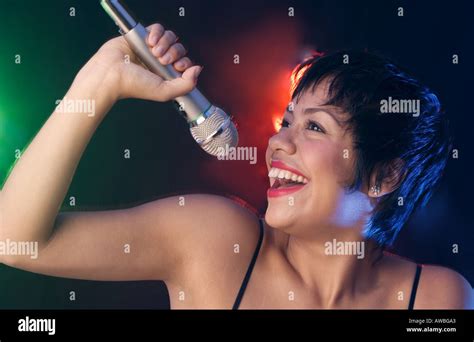 Woman Singing Into Microphone Stock Photo Alamy